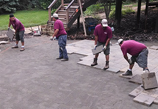 Team adding tiles to a backyard